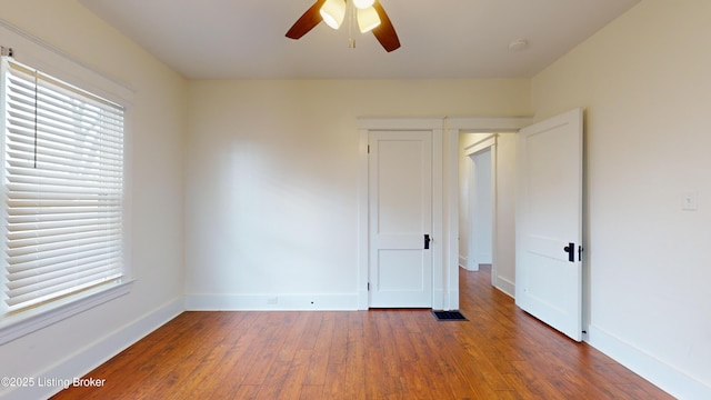 unfurnished room with ceiling fan and dark hardwood / wood-style flooring