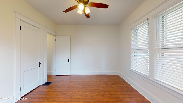 unfurnished room with ceiling fan and dark hardwood / wood-style flooring