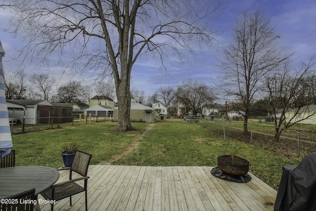 deck featuring a lawn, an outdoor fire pit, and grilling area