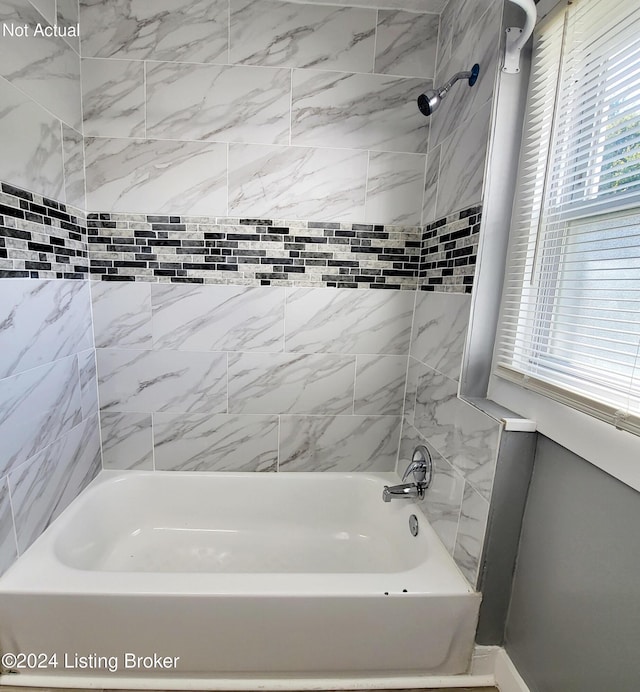 bathroom featuring plenty of natural light and tiled shower / bath combo