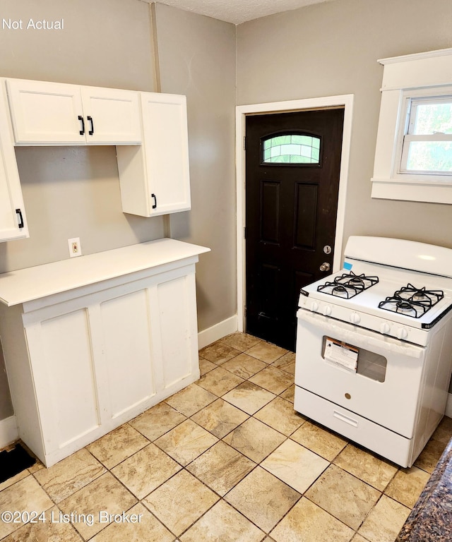 kitchen with white range with gas cooktop and white cabinets