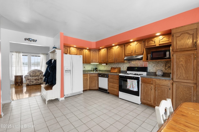 kitchen with decorative backsplash, light tile patterned flooring, and white appliances