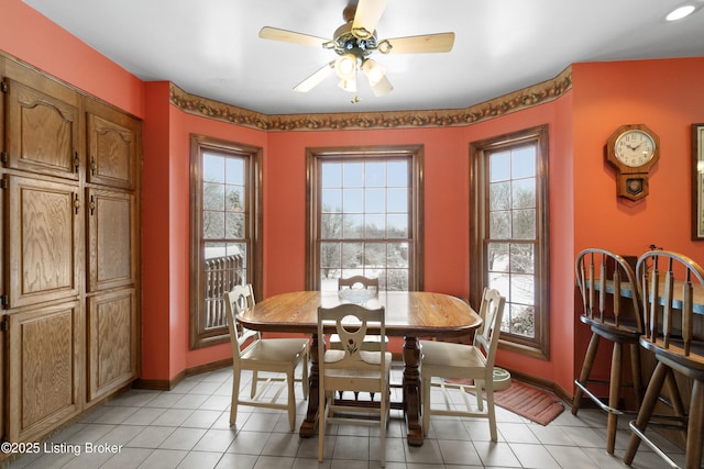 dining room featuring ceiling fan, light tile patterned floors, and a healthy amount of sunlight