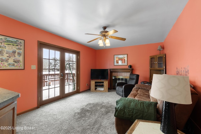 living room with ceiling fan, a fireplace, carpet floors, and french doors