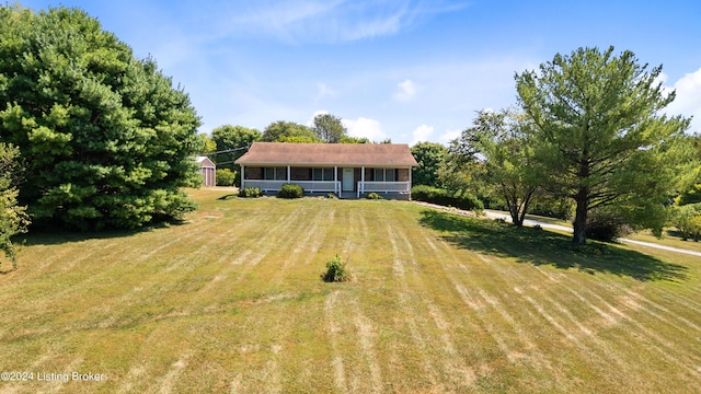 ranch-style home featuring covered porch and a front yard