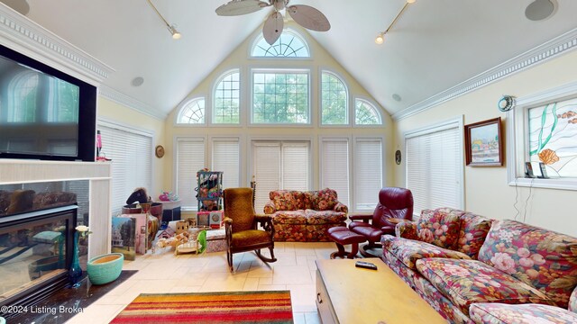 living room featuring ceiling fan, a premium fireplace, crown molding, and high vaulted ceiling