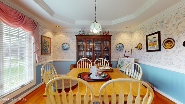 dining space featuring hardwood / wood-style floors, ornamental molding, and a tray ceiling