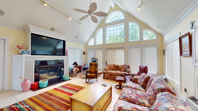 living room with ceiling fan, light tile patterned floors, ornamental molding, and high vaulted ceiling