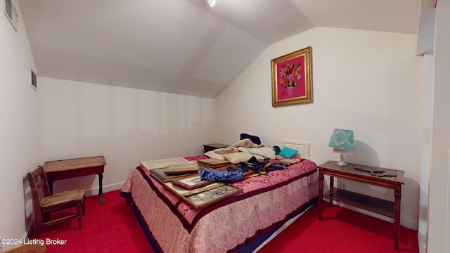 carpeted bedroom featuring lofted ceiling