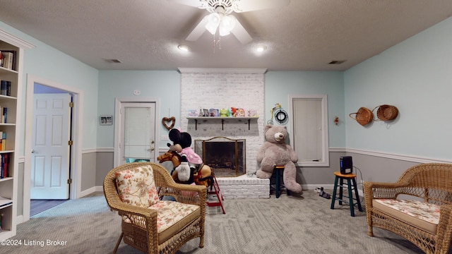 living room with carpet flooring, a fireplace, ceiling fan, and a textured ceiling