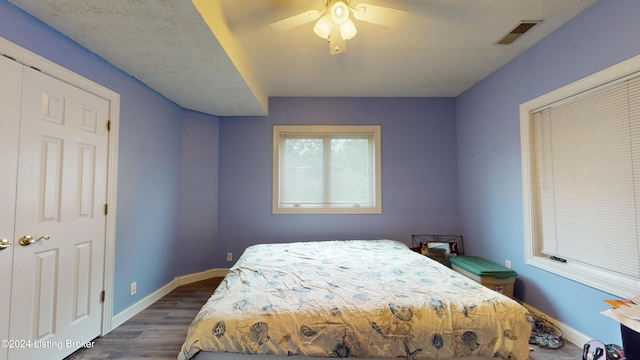 bedroom with ceiling fan, a closet, and dark hardwood / wood-style floors