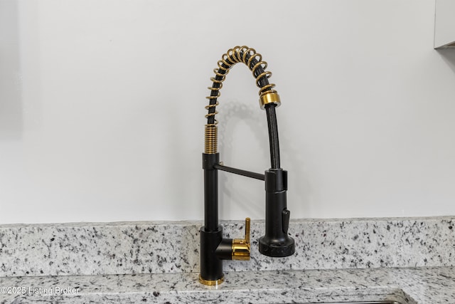 interior details featuring sink and light stone countertops