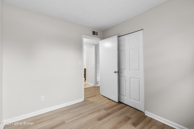 unfurnished bedroom featuring a closet and light hardwood / wood-style floors