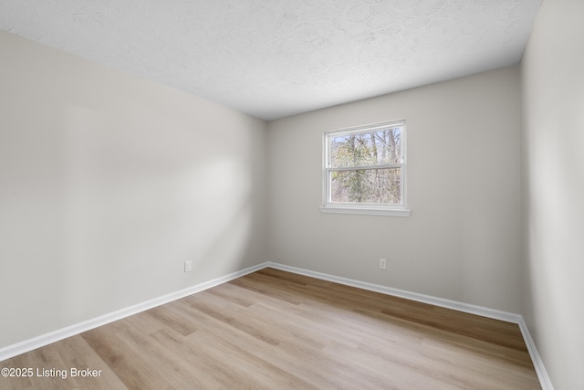 empty room featuring a textured ceiling and light wood-type flooring