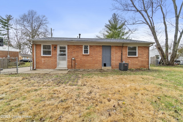 back of house with central air condition unit and a lawn