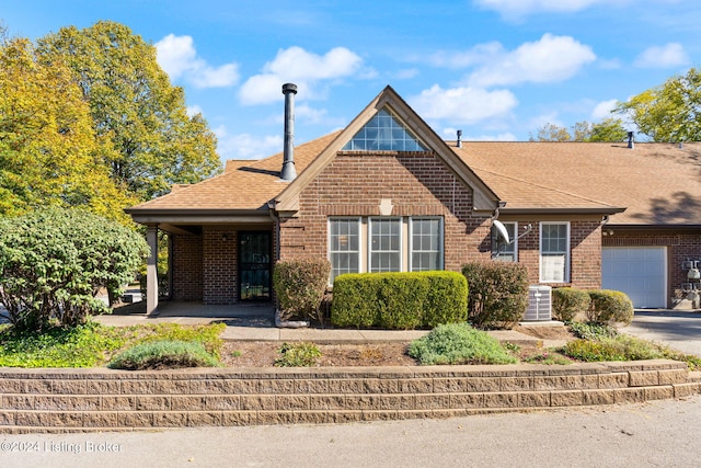 view of front of house with central air condition unit and a garage