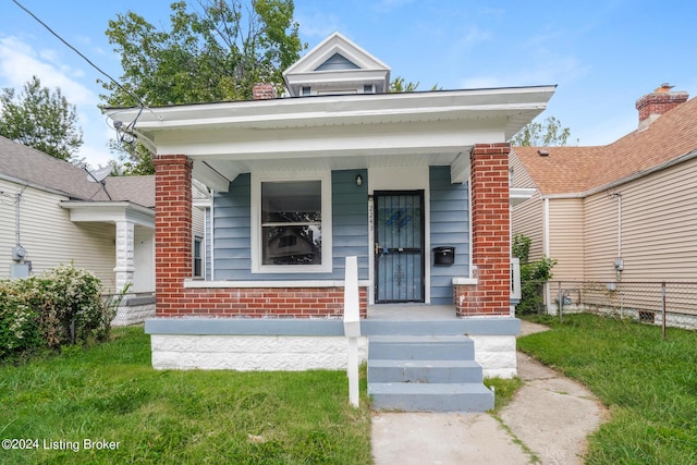 bungalow-style home with covered porch and a front yard