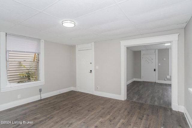 empty room featuring dark hardwood / wood-style flooring and a paneled ceiling