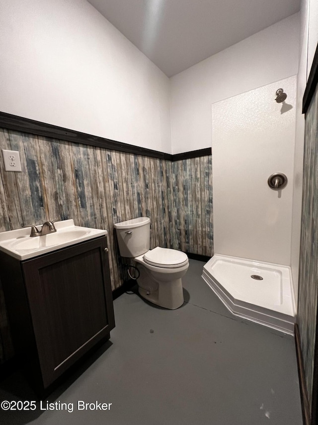 bathroom with vanity, toilet, concrete floors, and a shower