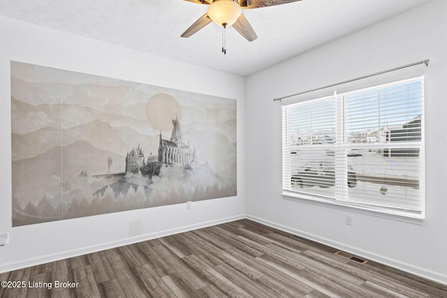 spare room with hardwood / wood-style flooring, ceiling fan, and a textured ceiling