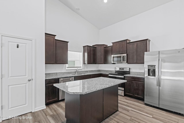 kitchen featuring dark brown cabinets, appliances with stainless steel finishes, sink, and a kitchen island