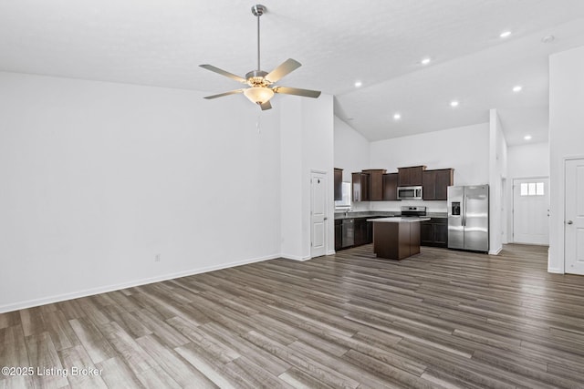 kitchen featuring a kitchen island, hardwood / wood-style floors, high vaulted ceiling, ceiling fan, and stainless steel appliances