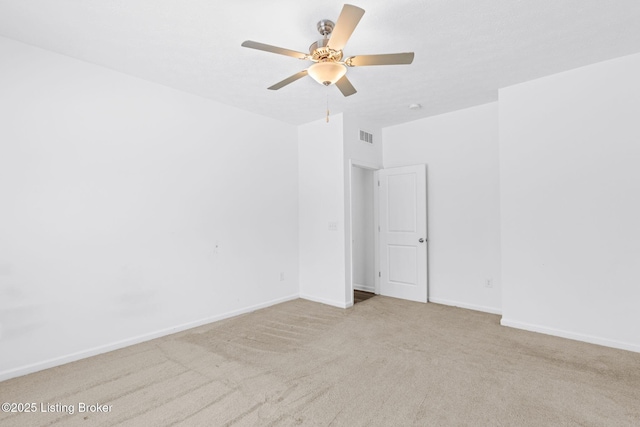 carpeted spare room featuring ceiling fan