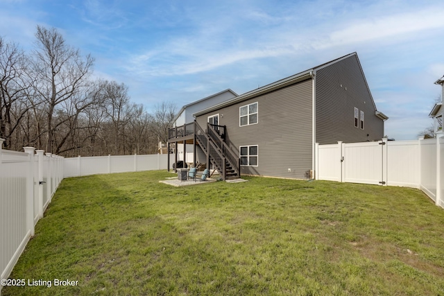 back of property with a yard, a deck, and a patio