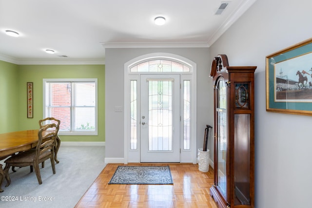 foyer with crown molding, a wealth of natural light, and light parquet floors