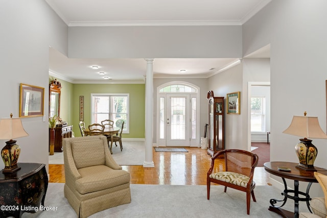 sitting room with ornate columns, crown molding, and light parquet flooring