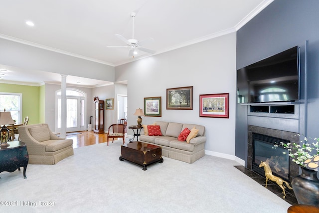 living room with ornamental molding, carpet floors, and a tile fireplace