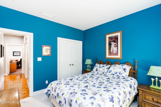 bedroom featuring a closet and light parquet flooring