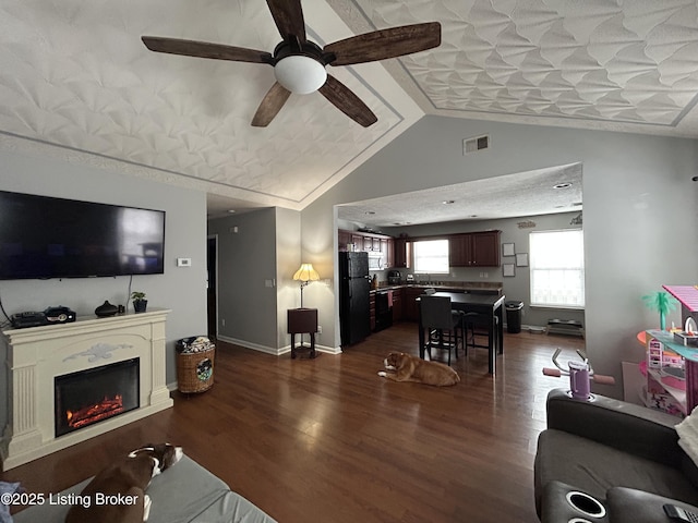 living room featuring vaulted ceiling, ceiling fan, and dark wood-type flooring