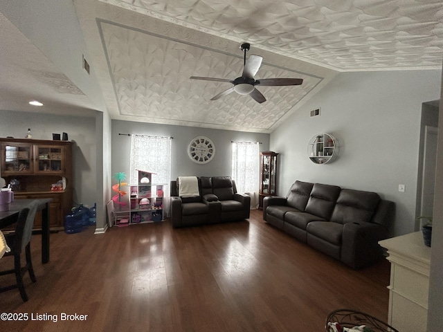 living room featuring a textured ceiling, ceiling fan, dark wood-type flooring, and vaulted ceiling