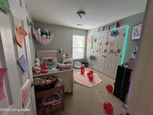 bedroom with a textured ceiling, light carpet, and a closet