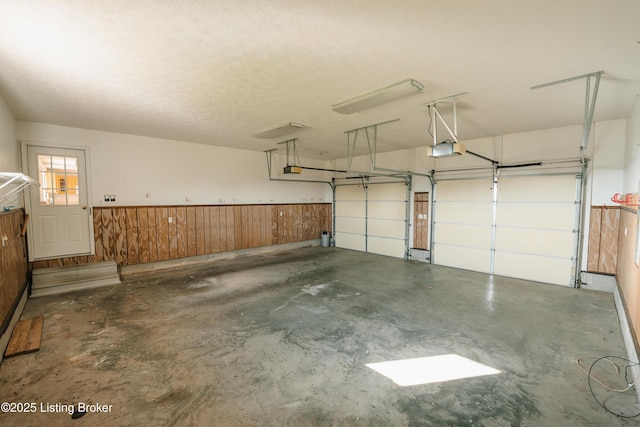 garage with wooden walls and a garage door opener