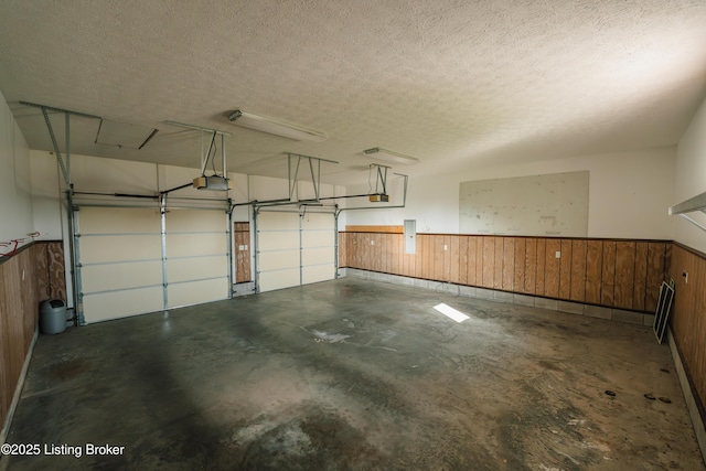 garage featuring wood walls and a garage door opener