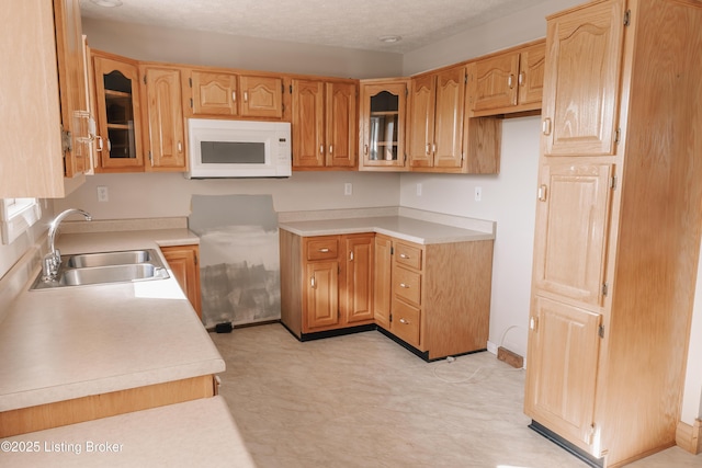 kitchen featuring a textured ceiling and sink