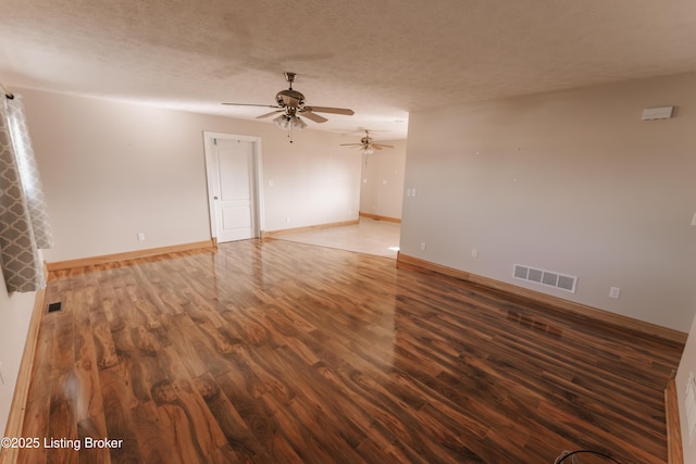 unfurnished room featuring a textured ceiling, dark hardwood / wood-style floors, and ceiling fan