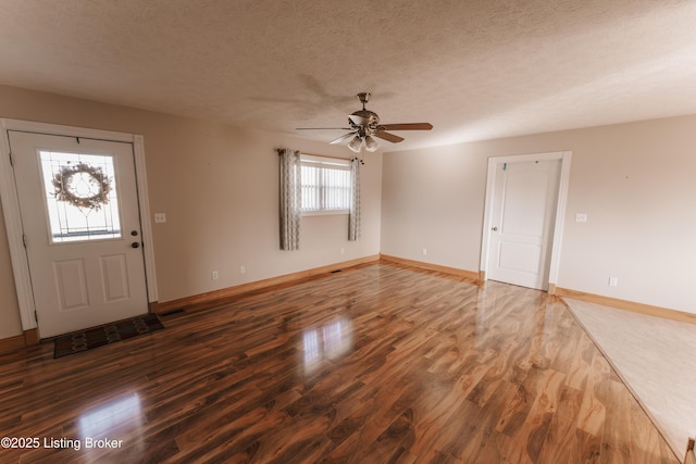 foyer entrance featuring ceiling fan, dark hardwood / wood-style floors, and a textured ceiling