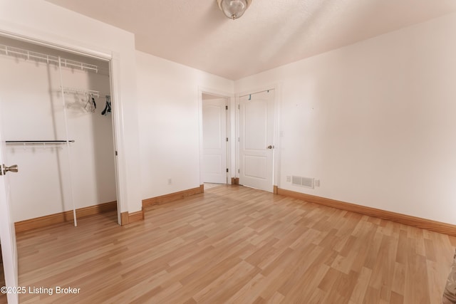 unfurnished bedroom featuring a closet and hardwood / wood-style flooring