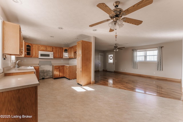 kitchen featuring ceiling fan, sink, and light hardwood / wood-style flooring