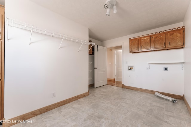 washroom with cabinets, hookup for a washing machine, a textured ceiling, and electric dryer hookup