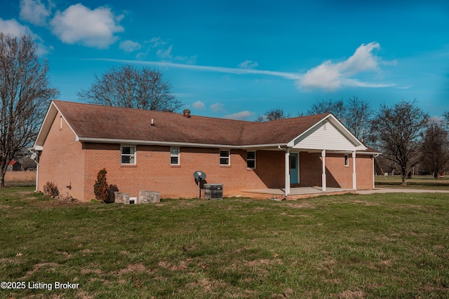 rear view of property with central AC unit and a yard