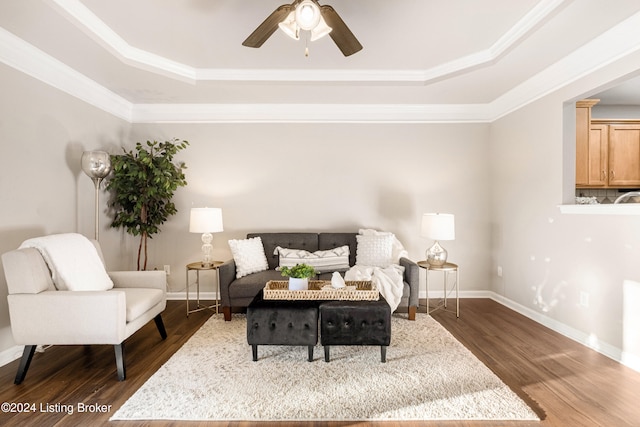 sitting room with a tray ceiling, crown molding, and dark hardwood / wood-style floors