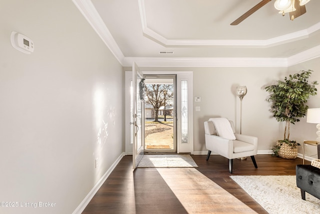 entryway with a tray ceiling, dark hardwood / wood-style floors, ornamental molding, and ceiling fan