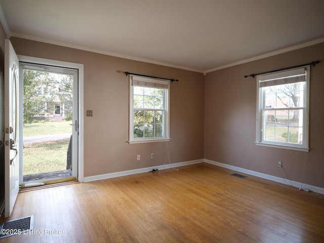 empty room featuring ornamental molding and light wood-type flooring