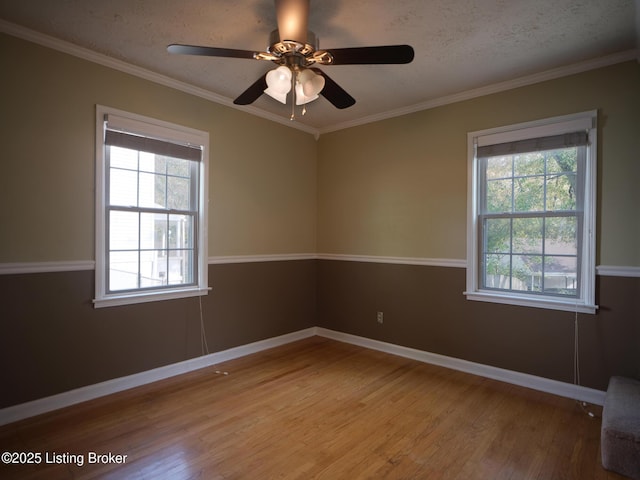 empty room featuring a textured ceiling, light hardwood / wood-style flooring, ceiling fan, and ornamental molding