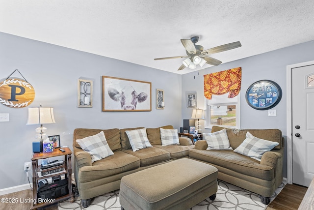 living room with ceiling fan, a textured ceiling, and light wood-type flooring