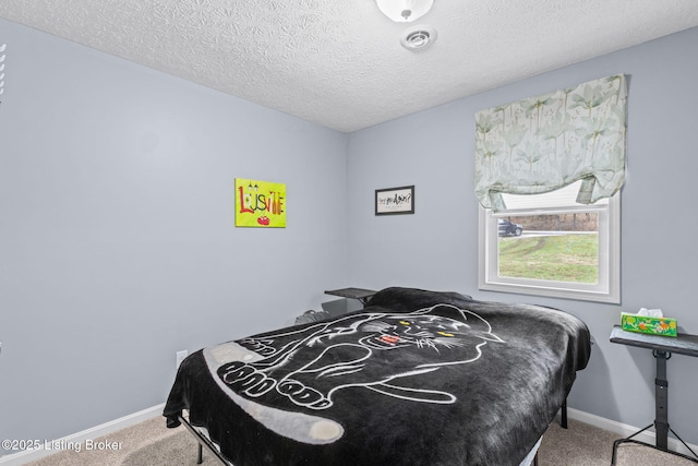 bedroom with carpet floors and a textured ceiling